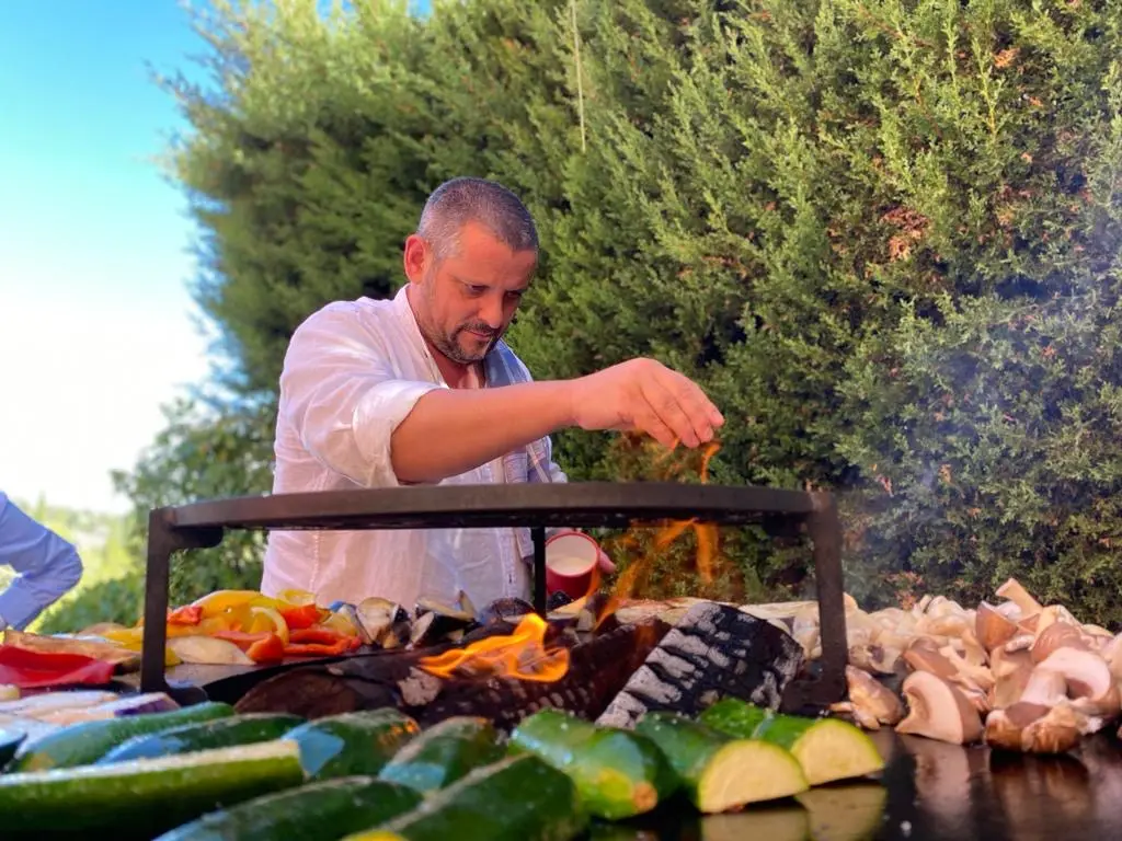 Chef bakt verse groenten en vlees op het open OFYR-vuur in de tuin van In den Hof